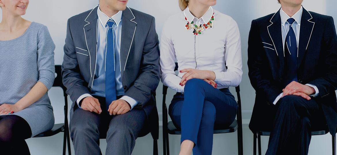 two people dressed in professional apparel sitting on a black chair