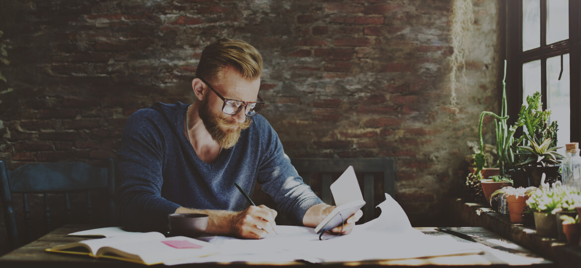 bearded man wearing glasses going over work documents